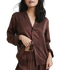 image of woman wearing the lunya washable silk pajamas in dozing umber holding up the shirt to see the elastic band 