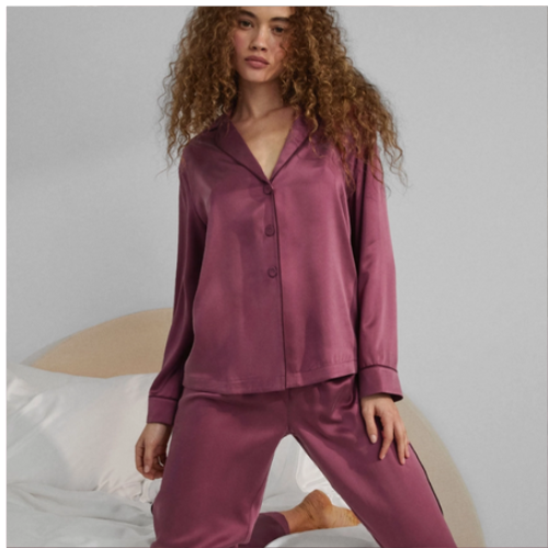 woman wearing lunya silk pajamas in winter rose / Calliope Wine 