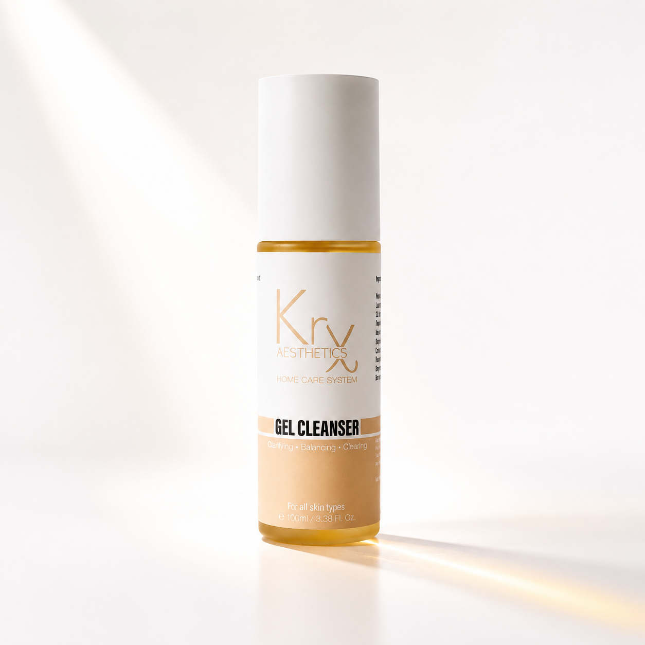 A bottle of Kry Aesthetics Gel Cleanser with a white cap and a beige and white label, set against a bright white background with soft diagonal light rays.