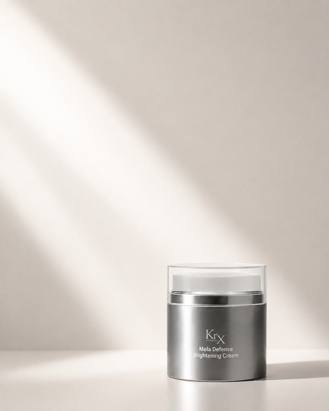 Krx Mela Defense Brightening Cream in a sleek silver jar with a clear lid, set against a warm beige background with dramatic diagonal light rays.