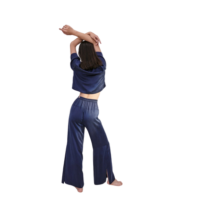 model from the back wearing the lunya washable silk high rise pant set in deep blue at heaven on earth aspen