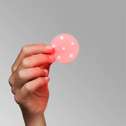 the omnilux mini skin corrector being held in the hand shows the red LED and Infrarard lights