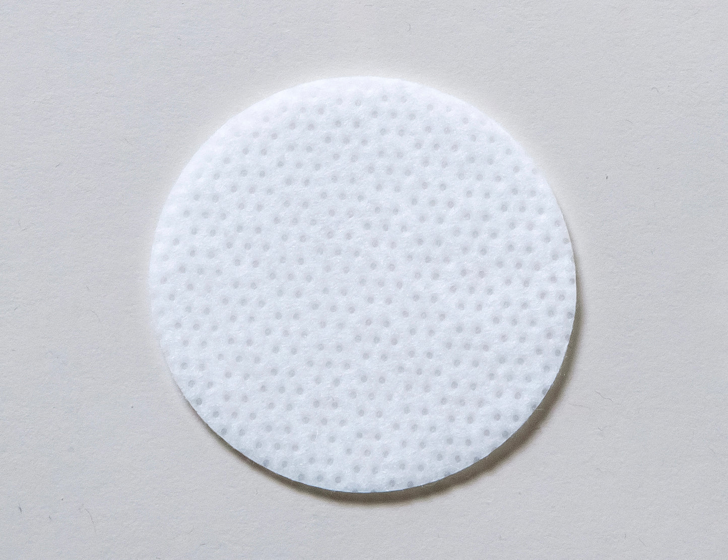 Round white skin script clarifying pad on a gray background - heaven on earth day spa and online store