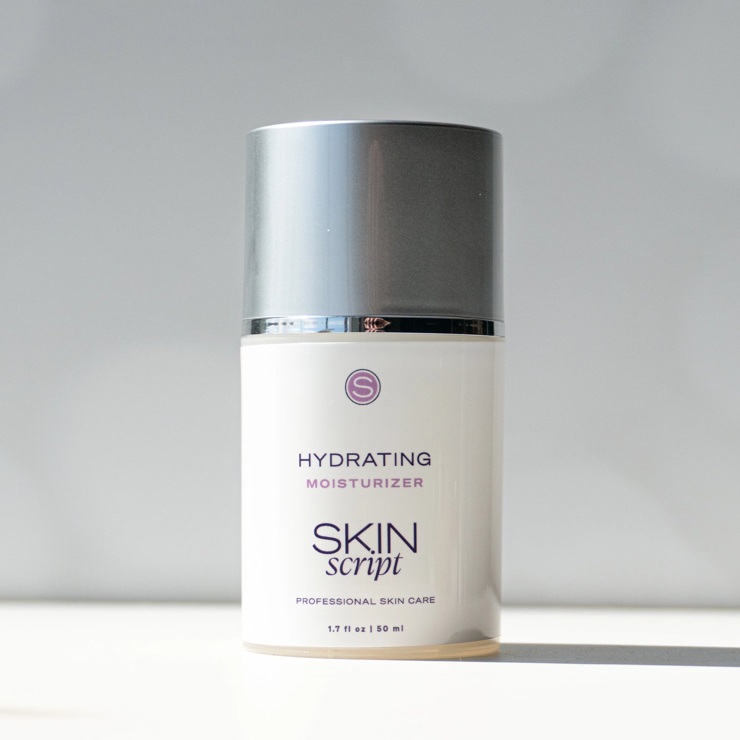 Skincare bottle labeled 'Hydrating Moisturizer' by 'Skin Script' on a gray background sold at heaven on earth aspen 