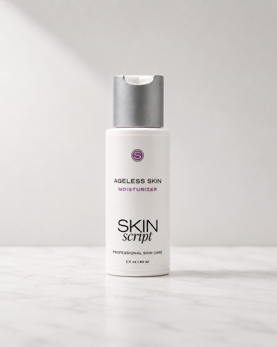 A white bottle of Skin Script Ageless Skin Moisturizer with a metallic silver pump, standing on a light marble surface against a neutral light gray background.