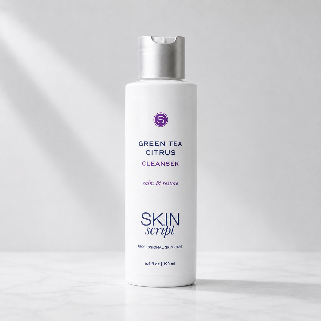 A white bottle of Skin Script Green Tea Citrus Cleanser with a silver cap, set against a clean white background with soft diagonal shadows.
