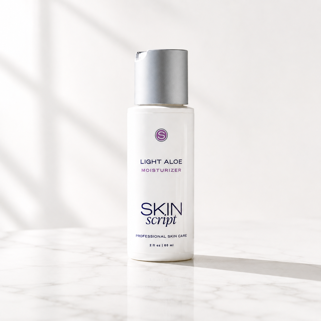 A white bottle of Skin Script Light Aloe Moisturizer with a metallic silver cap, standing on a white marble surface with soft window shadows.