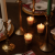 Candlelit scene with votivo spiced chai candle votives on a table in a dimly lit room