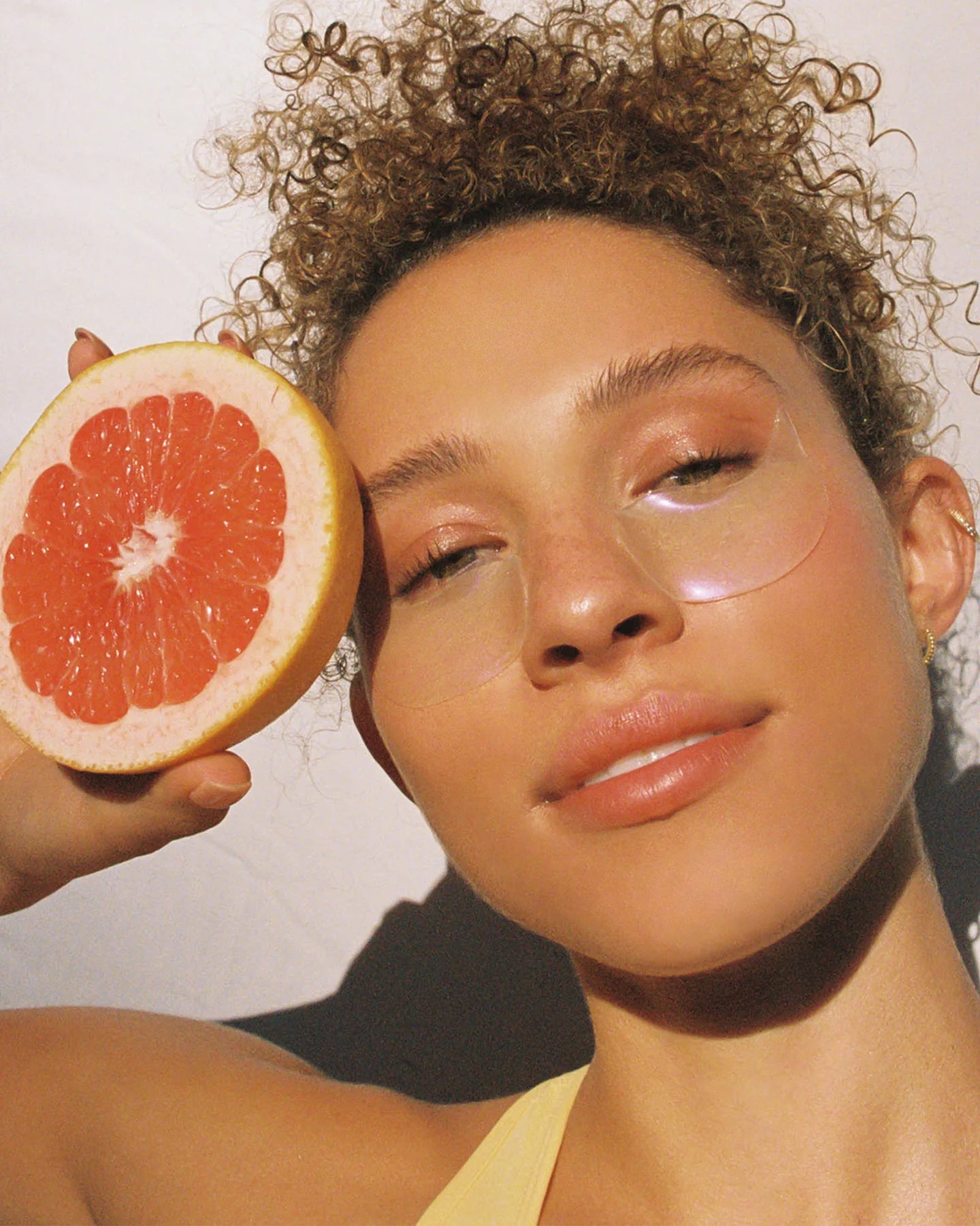 woman holding grapefruit wearing lapcos collagen gel eye mask from heaven on earth